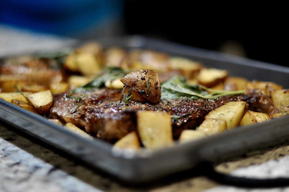 a tray of meat and potatoes on a table