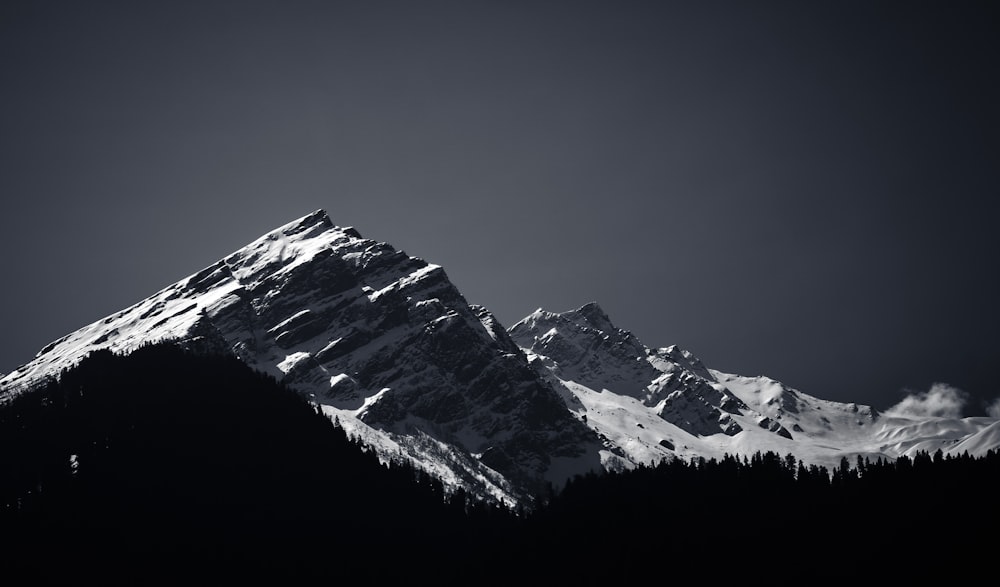 a black and white photo of a snow covered mountain