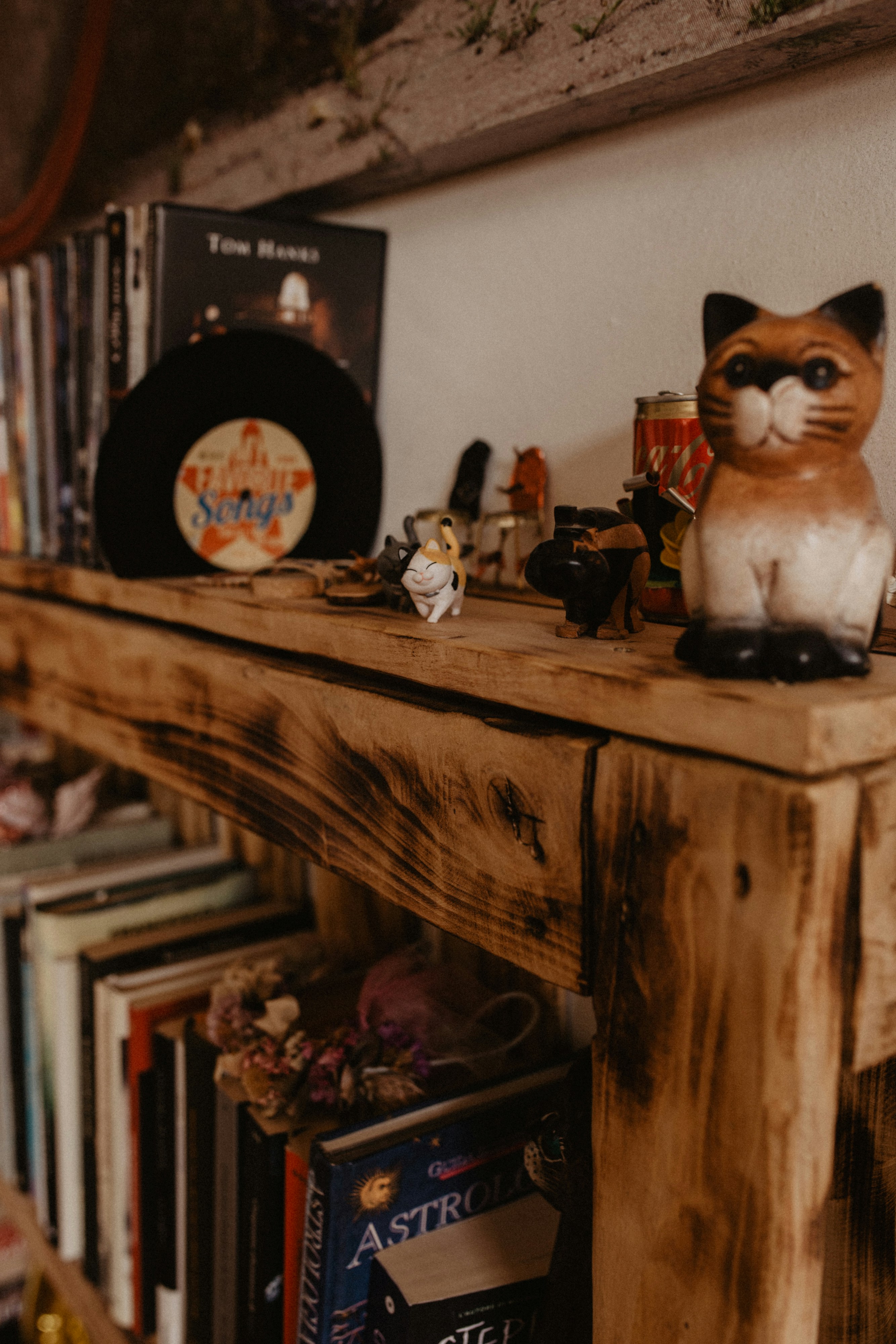a cat figurine sitting on top of a wooden shelf