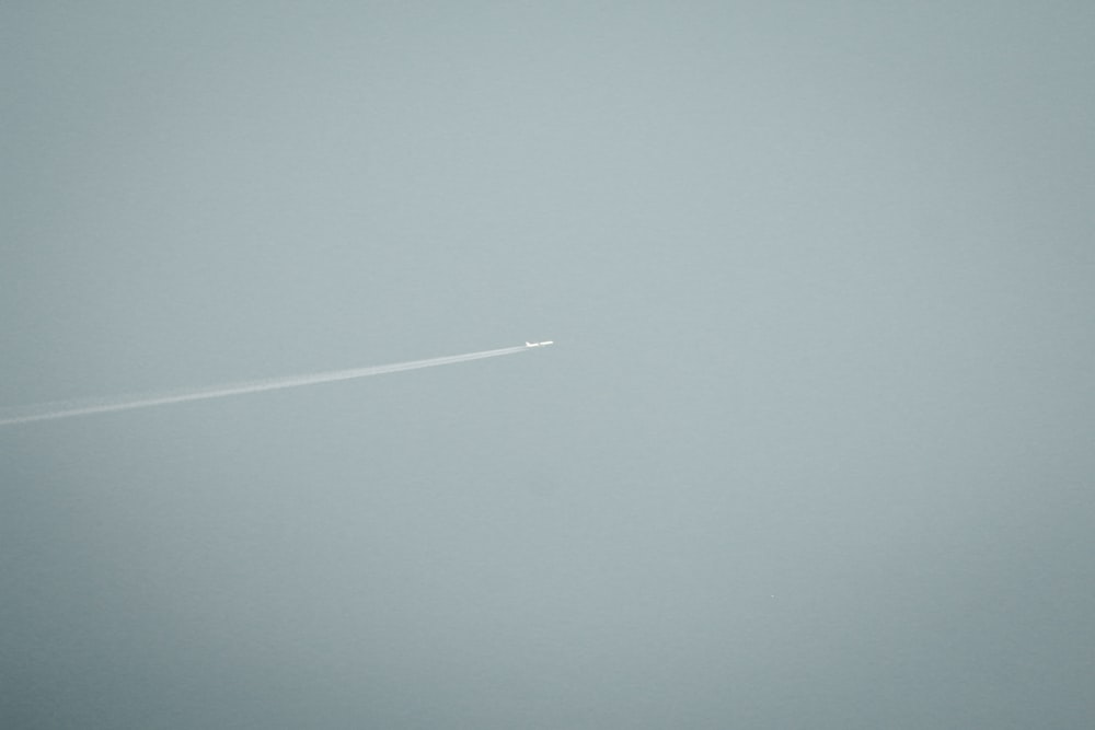an airplane flying in the sky on a foggy day