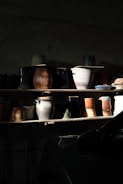 Close-up of decorative ceramic vases arranged on a wooden shelf.