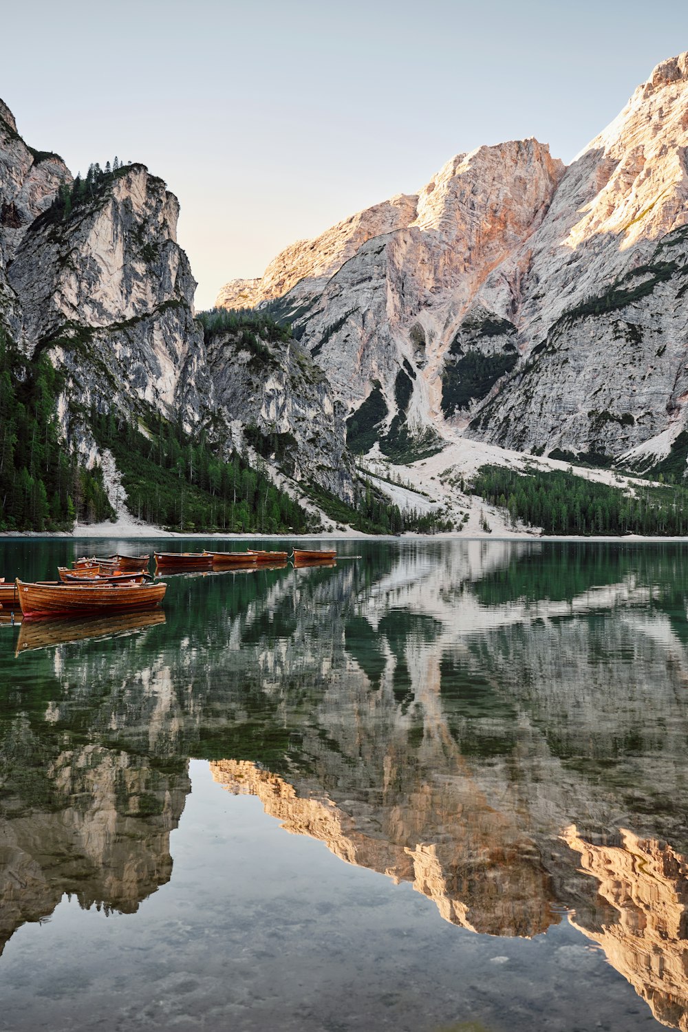 a mountain range is reflected in the still water of a lake