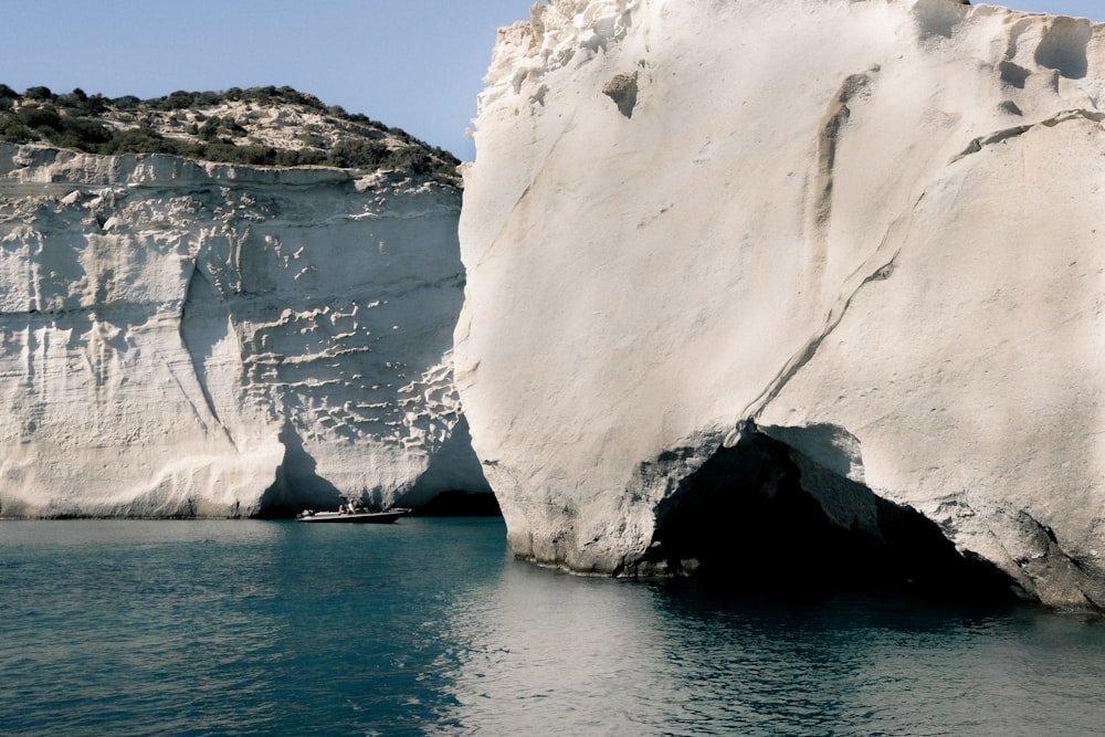 a large white rock sticking out of the water