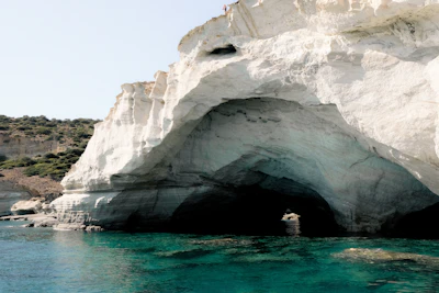 A white rock arch over turquoise water on the Milos coast