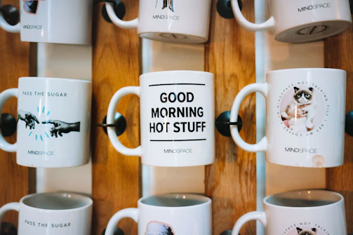 A set of mugs with different personalized messages arranged on a shelf.