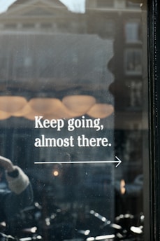 a window with a sign that says keep going, almost there
