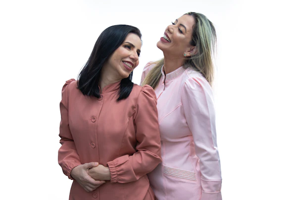 A joyful pair at a lively social event, with gentle pink lighting highlighting their friendly interaction.