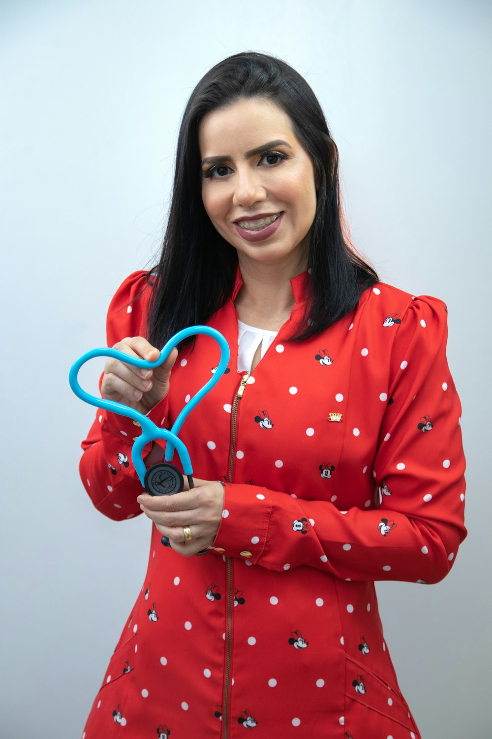 a woman in a red jacket holding a pair of scissors