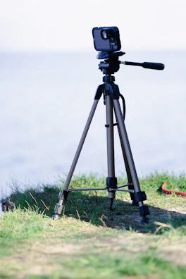 A sturdy tripod set up on uneven terrain, ready for action.
