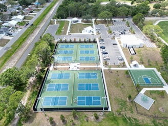 an aerial view of a tennis court and parking lot