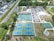 An aerial view of a sports complex featuring multiple tennis courts and a basketball court, surrounded by trees and a parking area with vehicles. There are paths leading to the courts, and a few small buildings nearby.