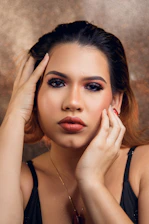 A close-up of a person applying vibrant makeup in a cozy studio.