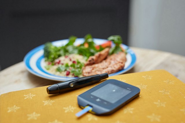 Mahlzeit und Blutzuckermessgerät auf dem Tisch
