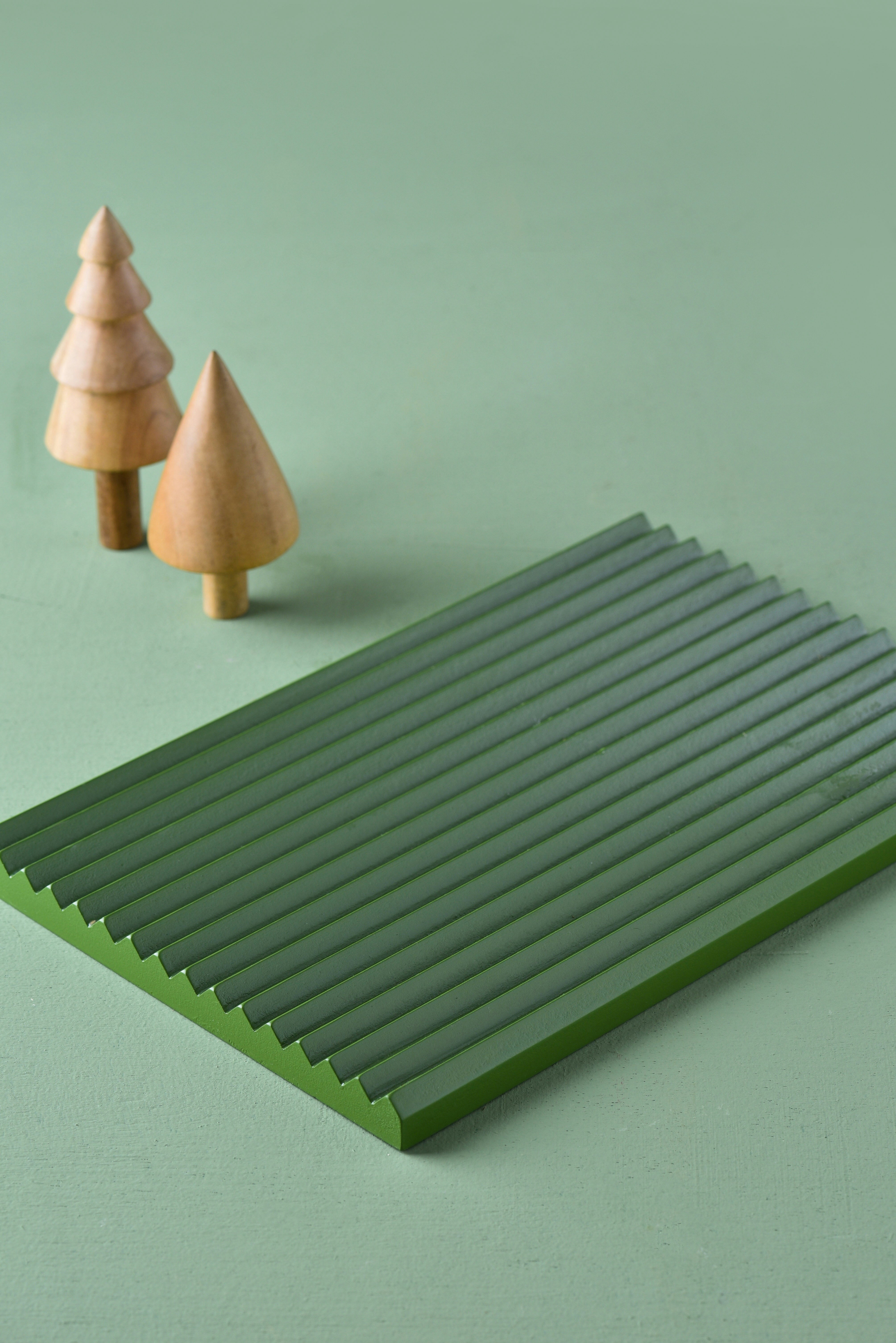 a green table with two small wooden trees