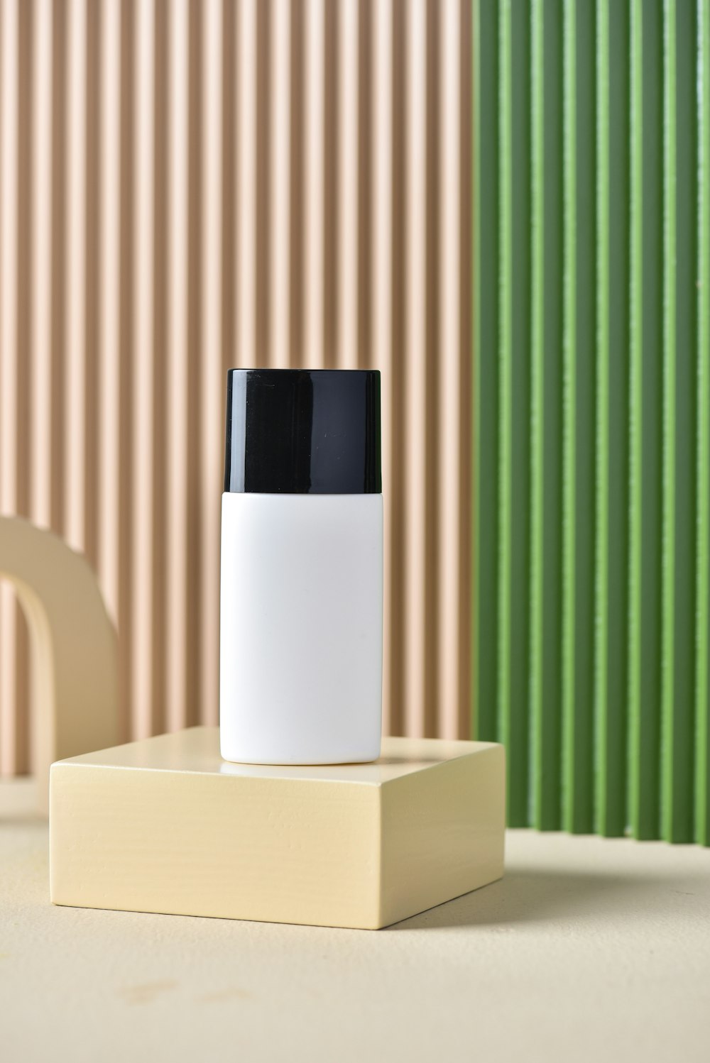 a white and black bottle sitting on top of a wooden block