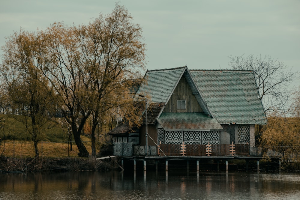 a house sitting on top of a lake next to a forest