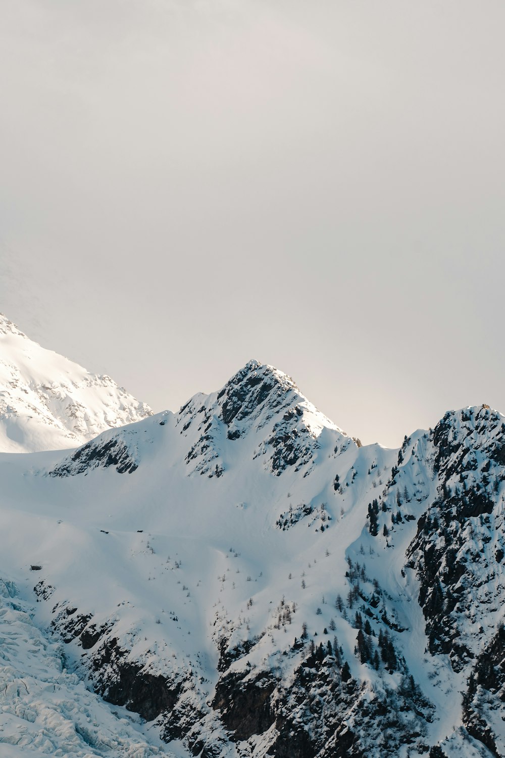 a mountain covered in snow with a sky background