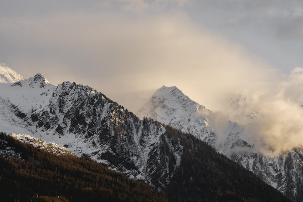 a mountain range covered in snow and clouds