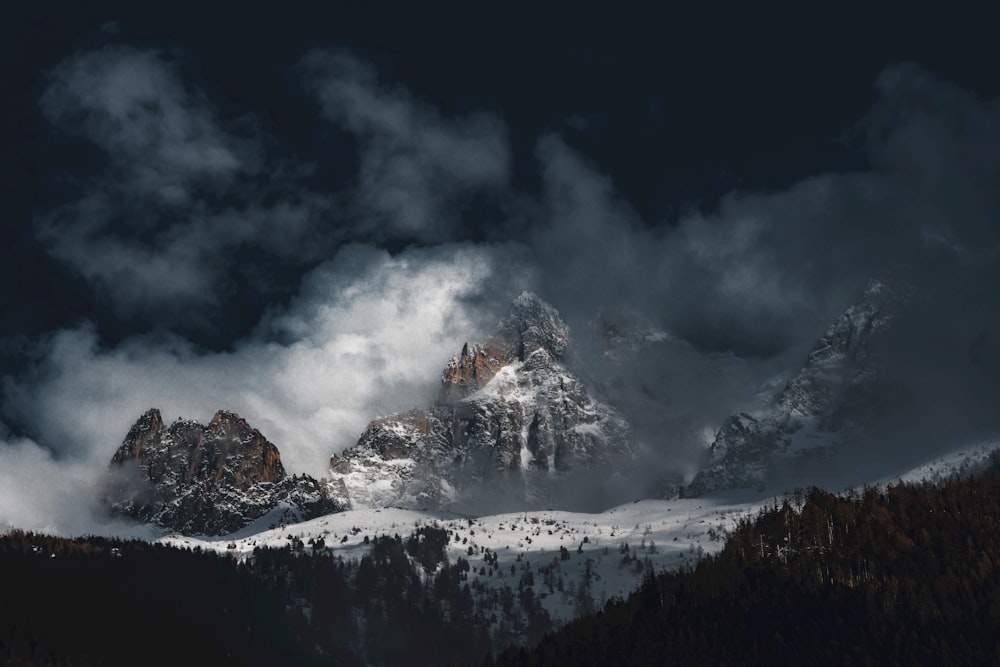 a mountain covered in snow and clouds at night