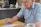 Happy elderly man reviewing documents at a bright kitchen table