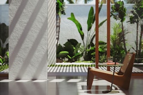 A sunlit room featuring a mid-century modern chair paired with a small curated side table.