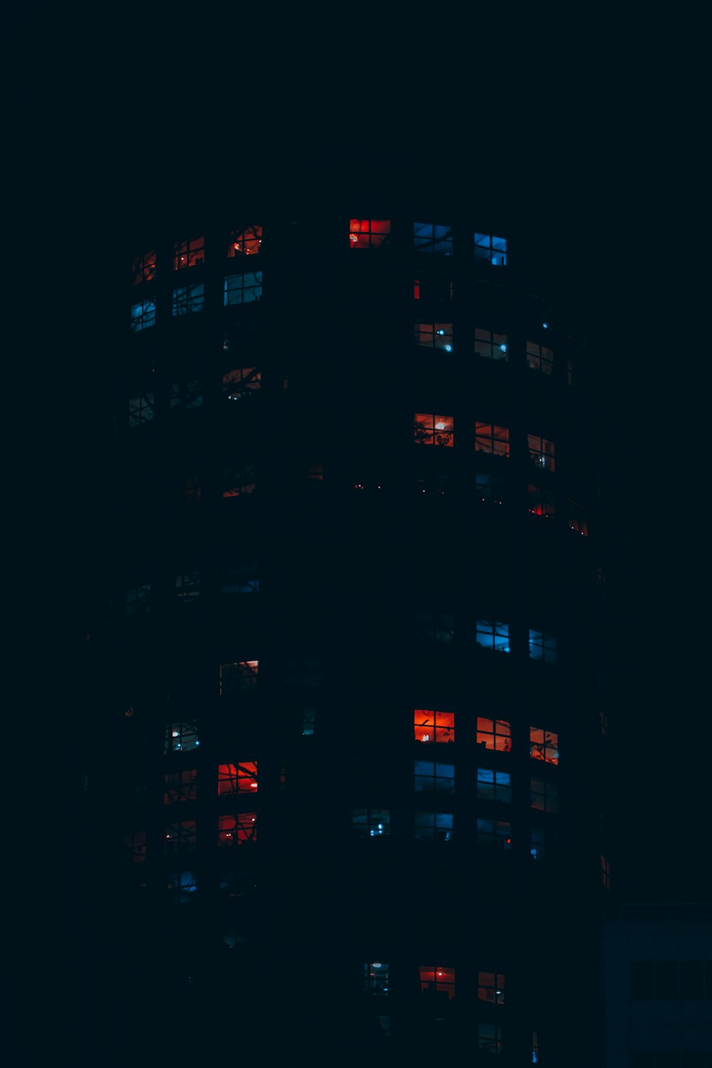 a tall building with many windows lit up at night