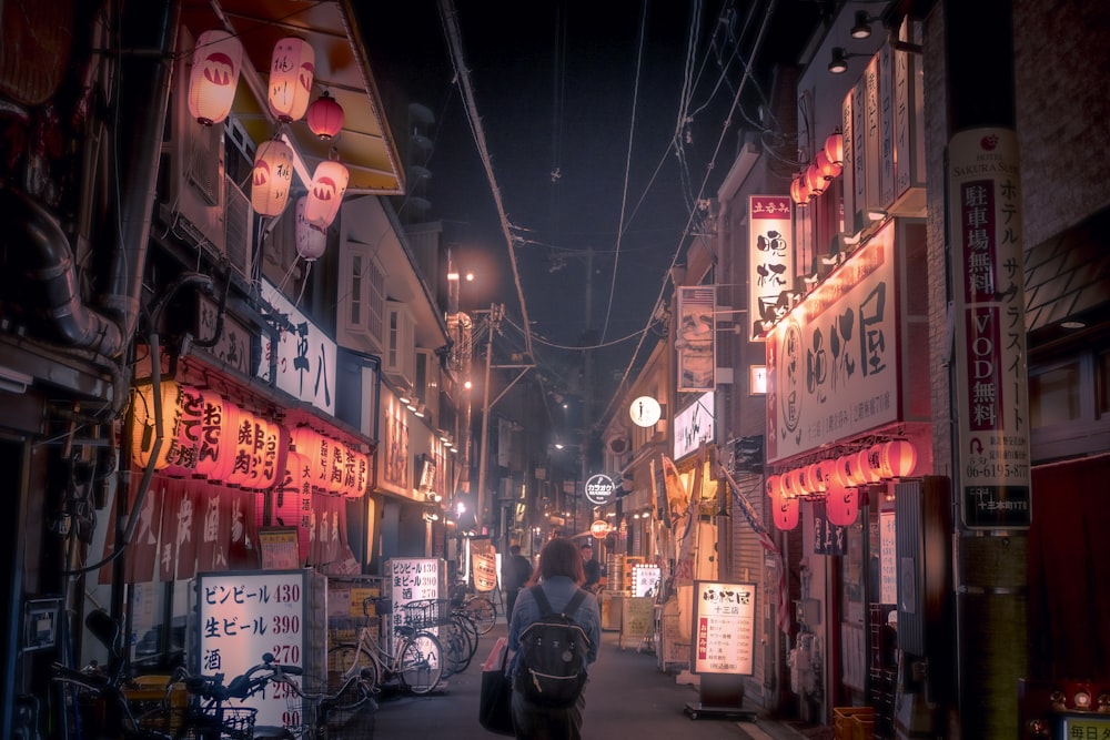 a person walking down a street at night