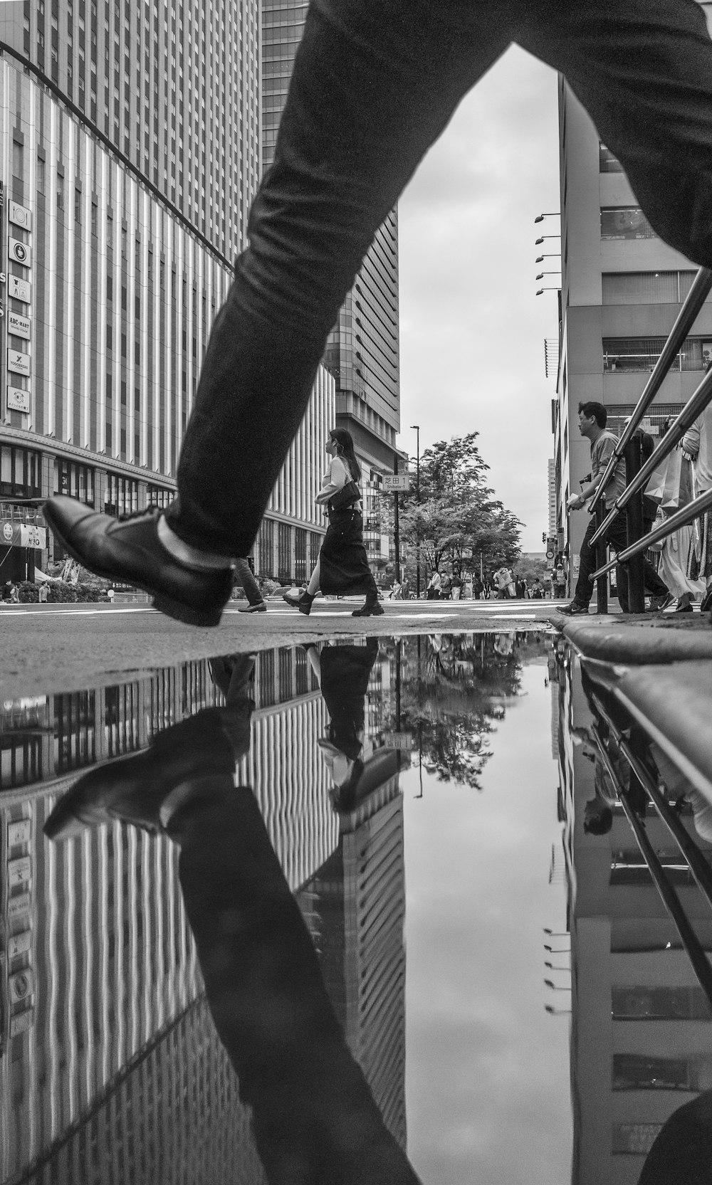 a black and white photo of a person walking on a sidewalk