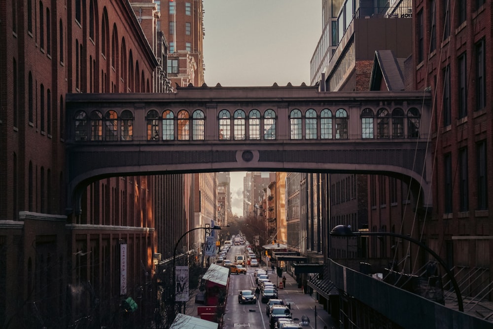 a city street filled with lots of traffic under a bridge