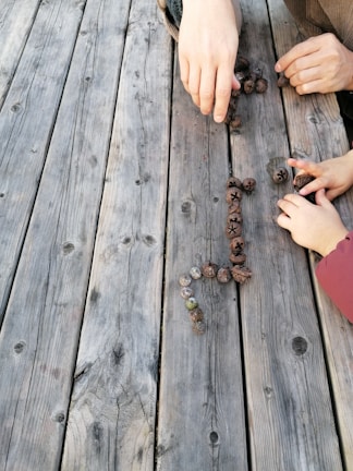 Hands arranging figurines for a family constellation exercise.