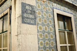 Close-up of traditional blue and white azulejos tiles on a sunny plaza wall.