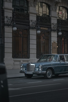 Luxury Mercedes van parked near the Acropolis at dusk, bathed in soft golden light.