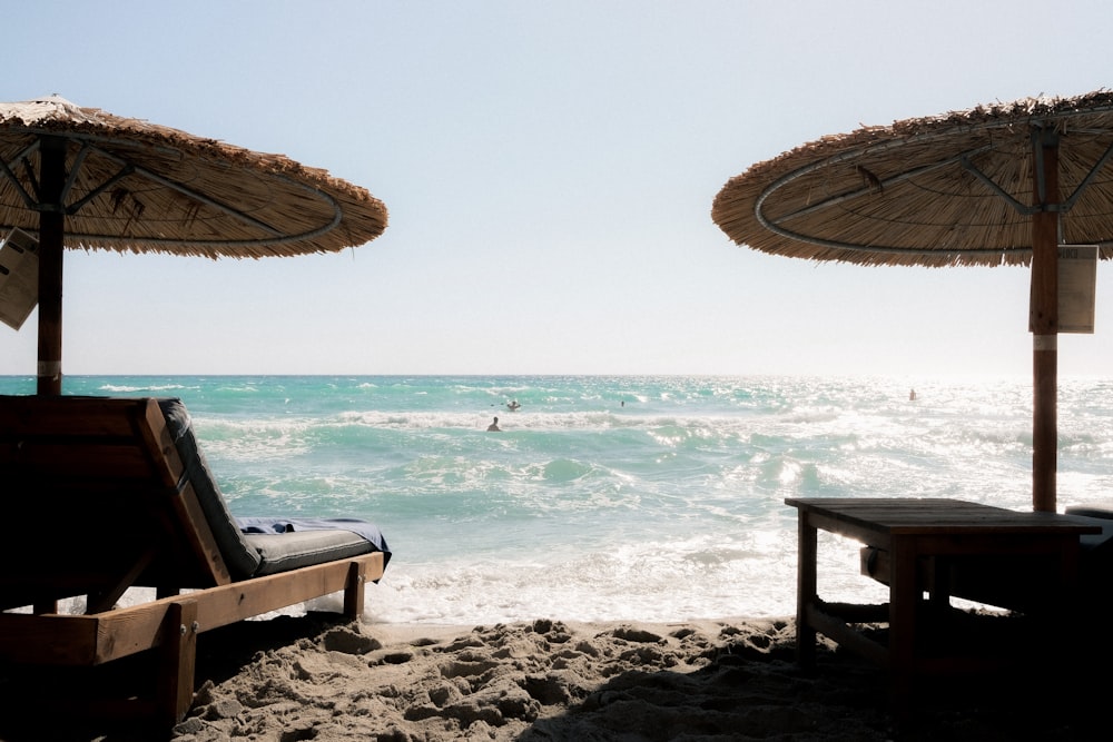 a couple of umbrellas sitting on top of a sandy beach