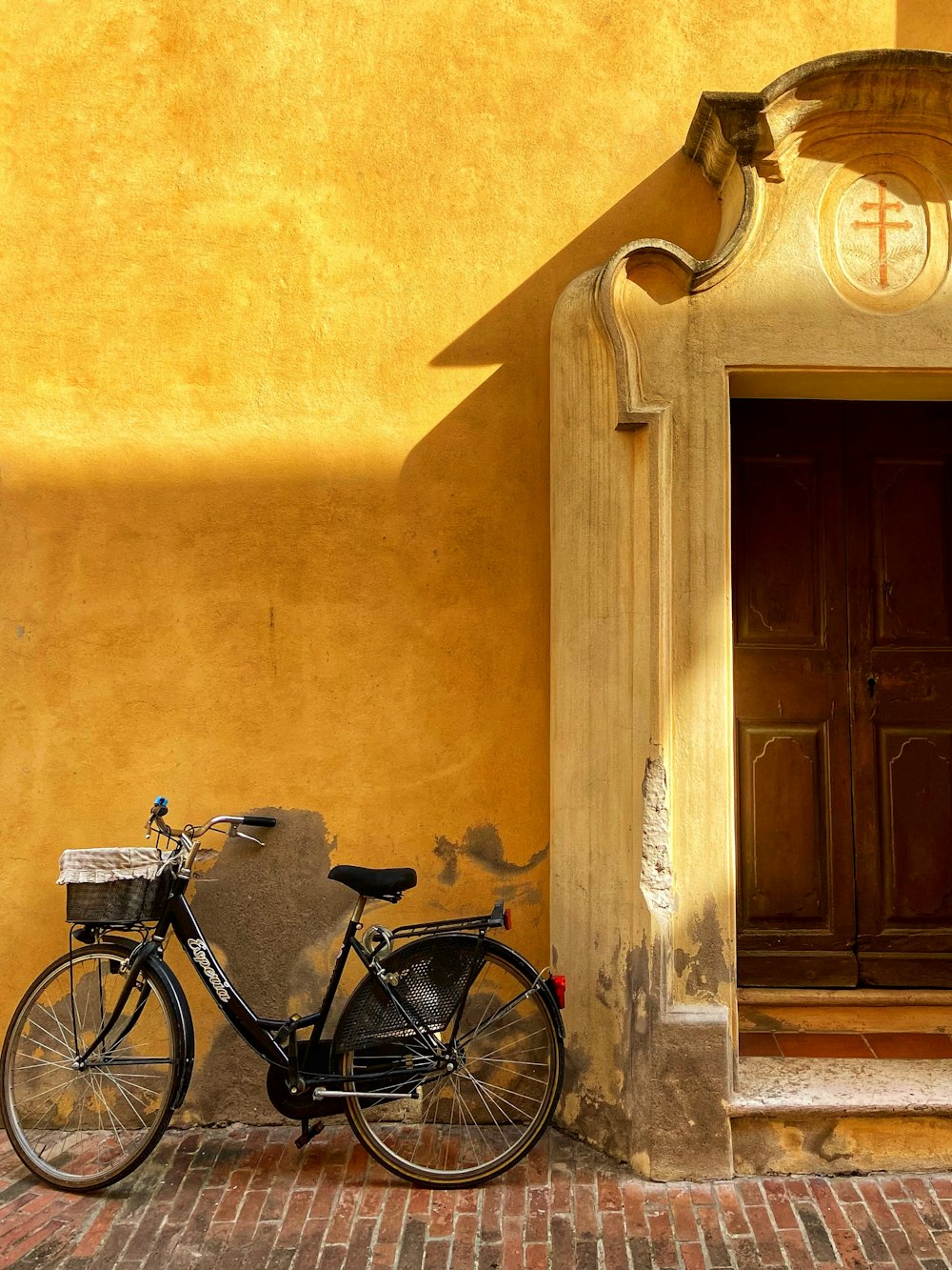 a bicycle parked in front of a yellow building