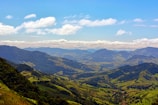 A panoramic view of Ireland’s rolling green landscapes under a blue sky.