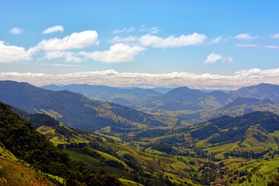 A panoramic view of the rolling green hills along Route 1 in San José, Uruguay, under a bright blue sky.