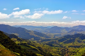 A panoramic shot of the lush Salvadoran mountains under a bright blue sky, taken by a club member.