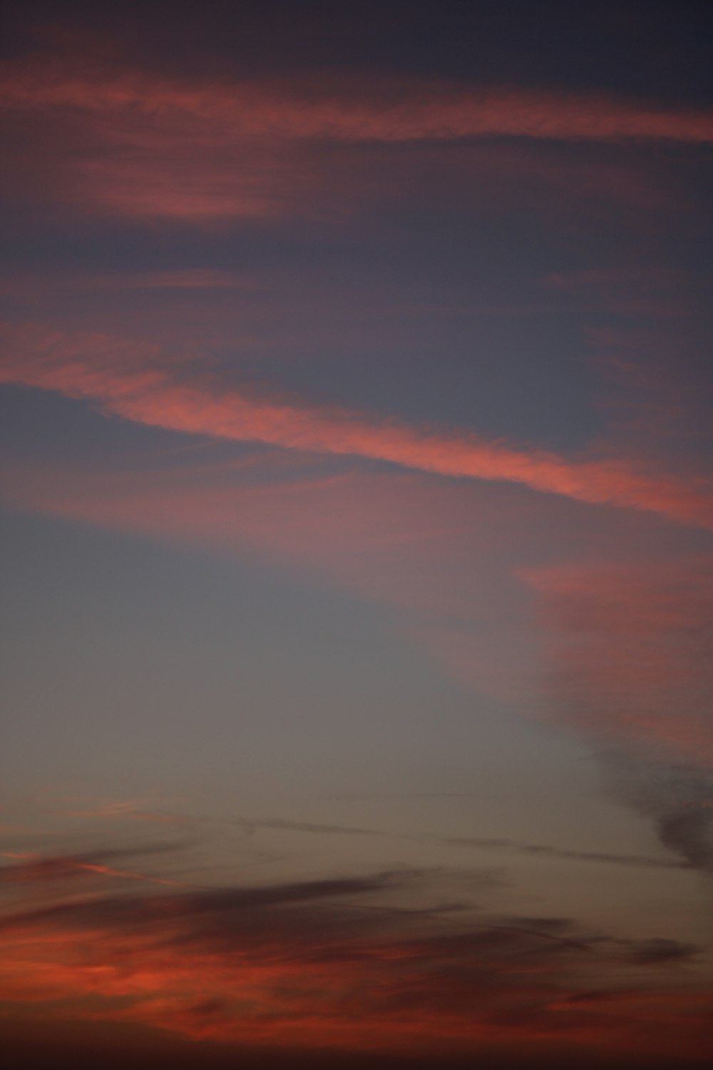 a plane flying in the sky at sunset