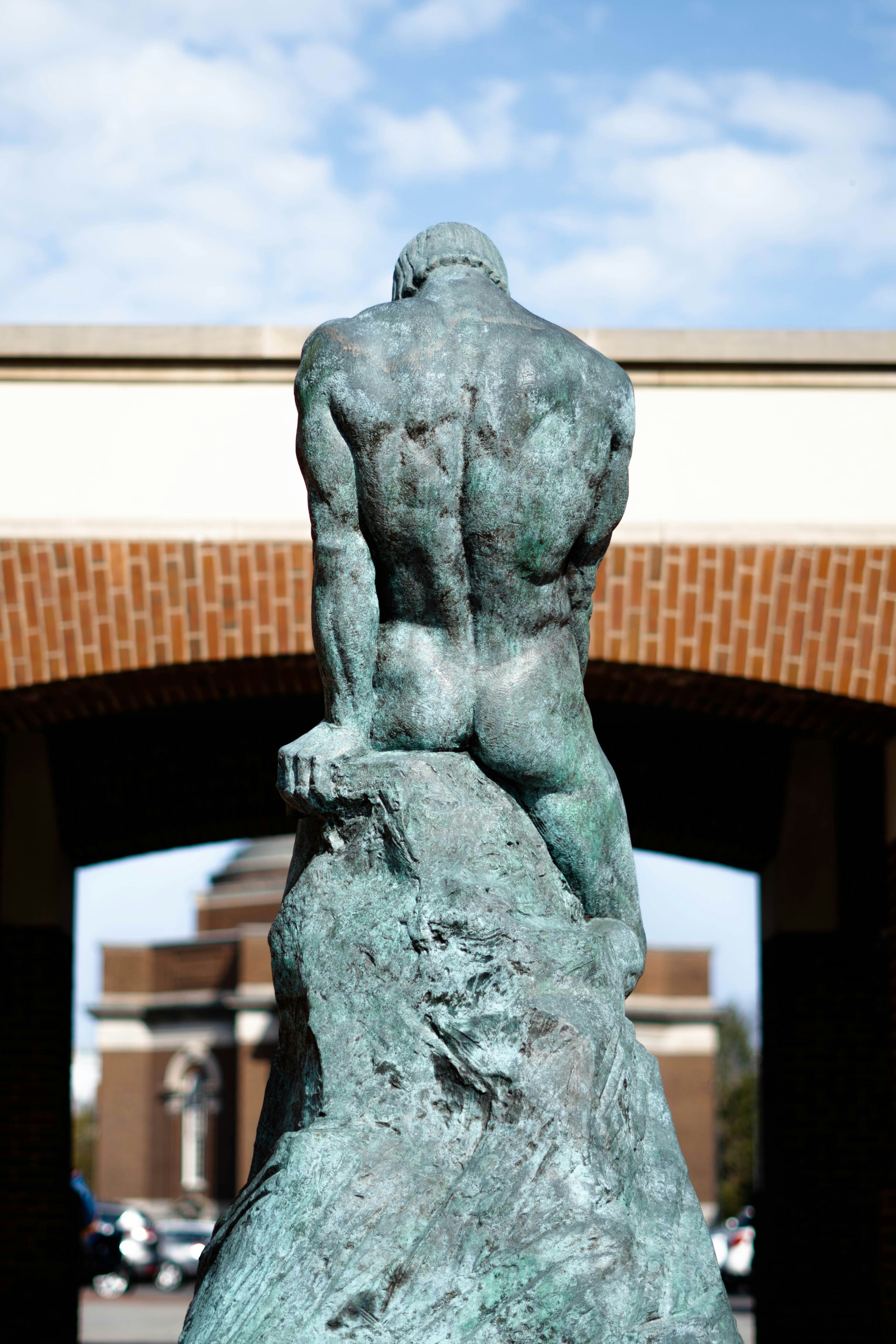 a statue of a man sitting on top of a rock