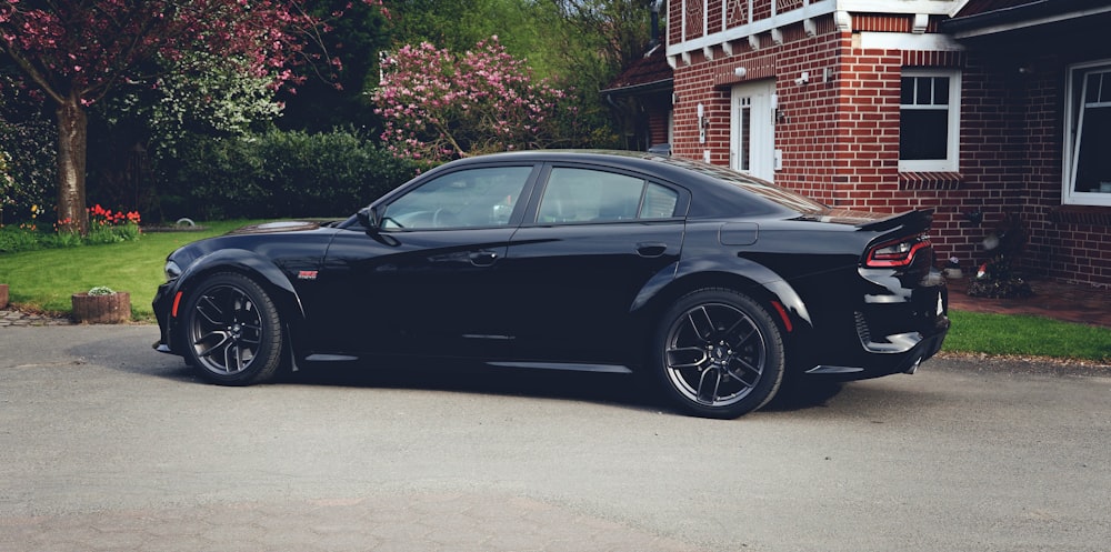 a black sports car parked in front of a house