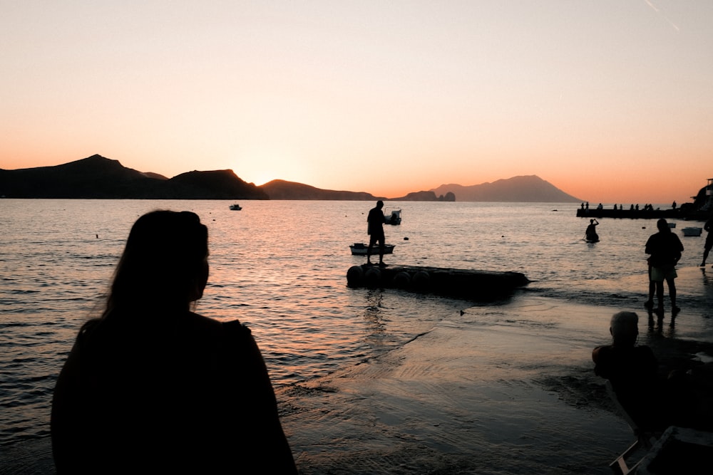 a group of people standing on top of a body of water