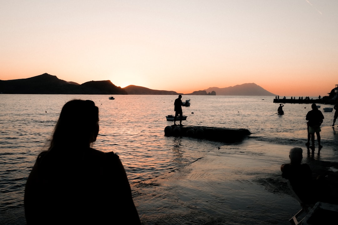 a group of people standing on top of a body of water,