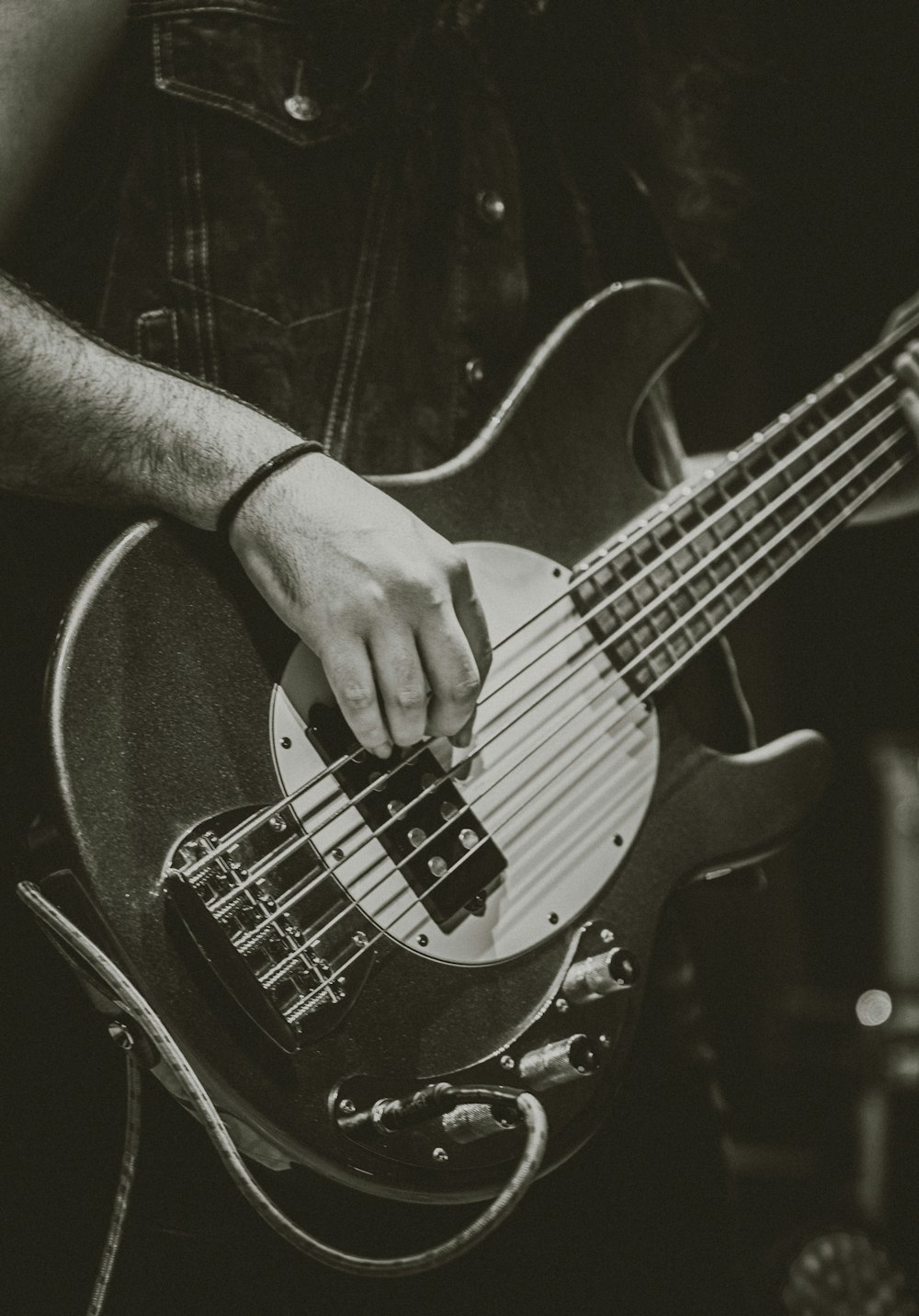 a black and white photo of a man playing a bass guitar