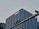 A tall, modern office building with a grid-like facade of windows is prominently visible. The logo and name 'China Merchants Bank' are displayed in white and red on the top of the building. In the foreground, there is a traffic light hanging on a metal pole.