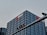 A tall, modern office building with a grid-like facade of windows is prominently visible. The logo and name 'China Merchants Bank' are displayed in white and red on the top of the building. In the foreground, there is a traffic light hanging on a metal pole.