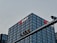 A tall, modern office building with a grid-like facade of windows is prominently visible. The logo and name 'China Merchants Bank' are displayed in white and red on the top of the building. In the foreground, there is a traffic light hanging on a metal pole.