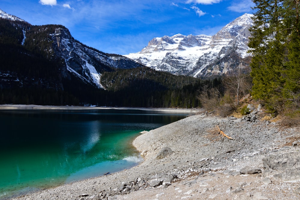 a mountain lake surrounded by snow covered mountains