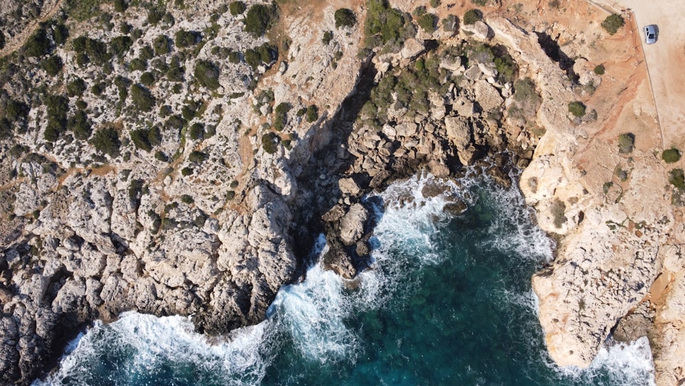 an aerial view of a rocky coastline and a body of water
