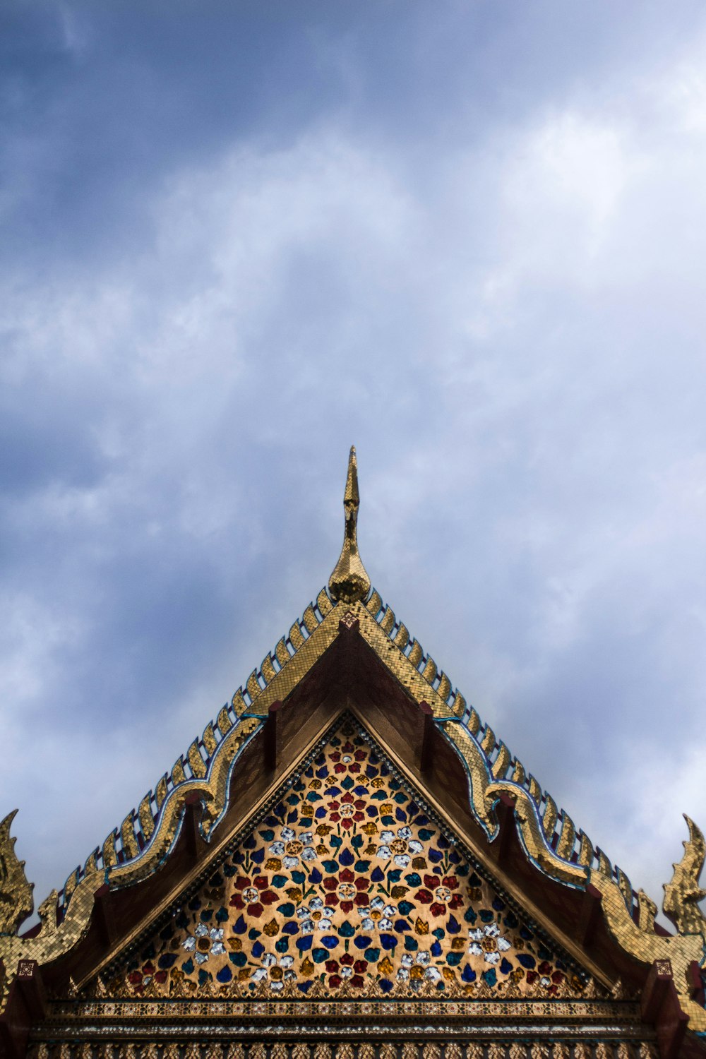 a building with a decorative roof and a sky background