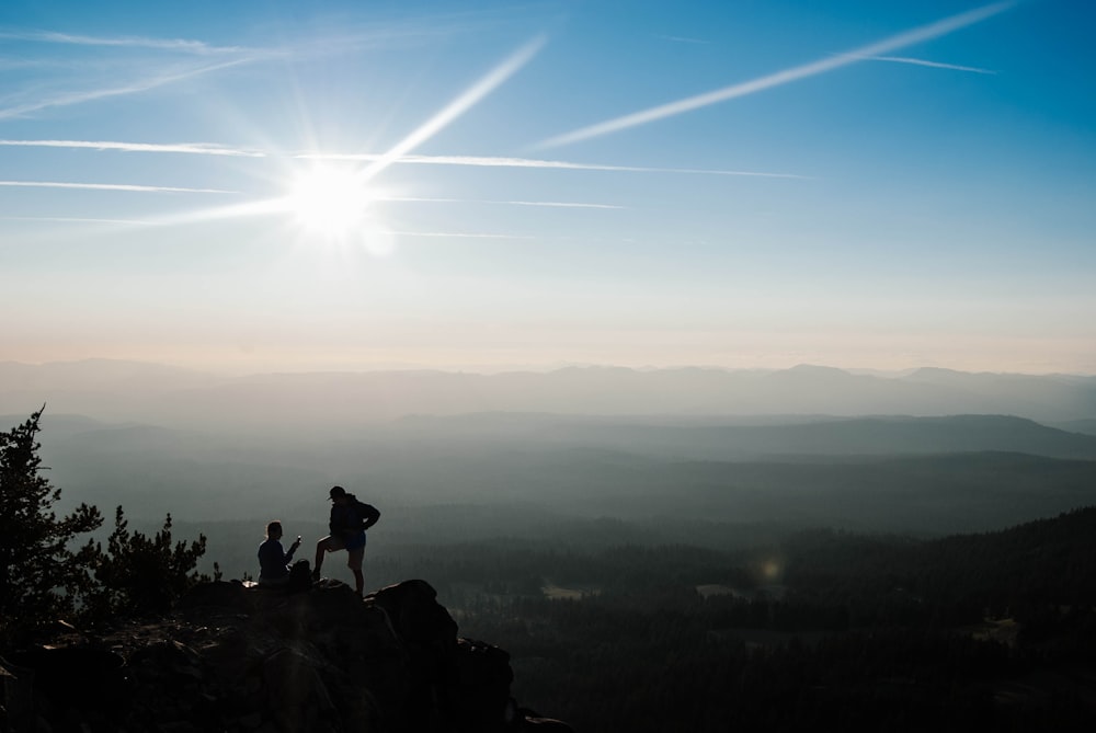 a couple of people standing on top of a mountain